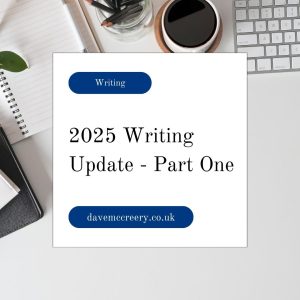 White box with blog title "2025 Writing Update - Part One" over a background of a desk